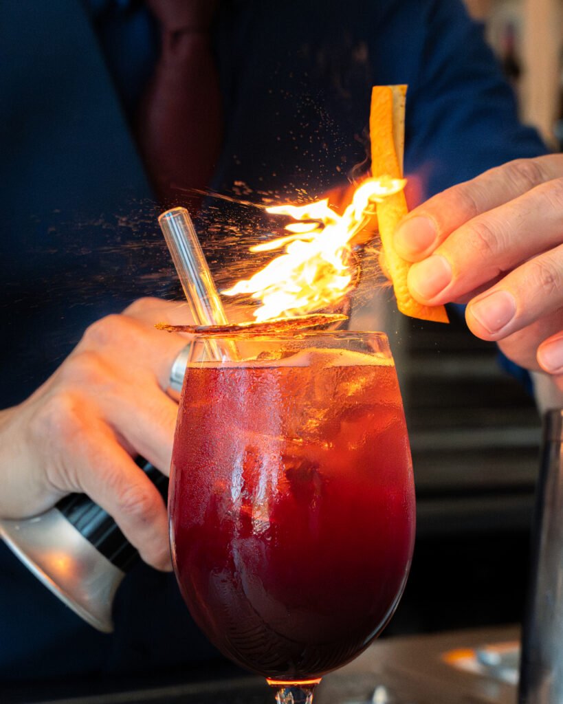 Cocktail fumé avec zeste d’orange flambé préparé par un bartender au bar Nektar à Bordeaux