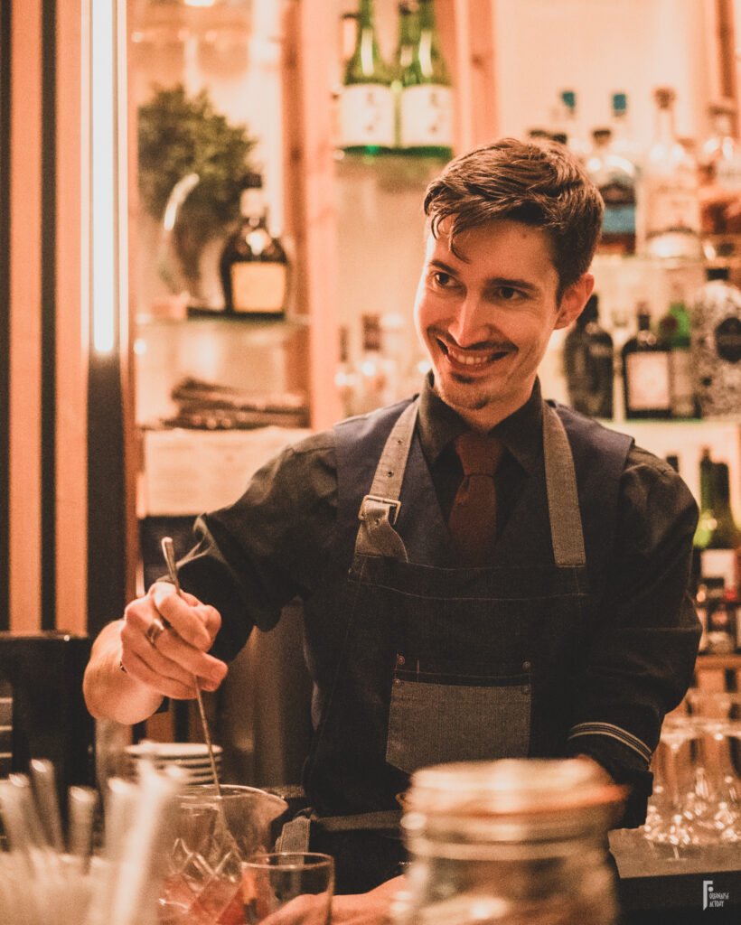 Barman mélangeant un cocktail à la cuillère dans un verre à mélange au bar Nektar à Bordeaux