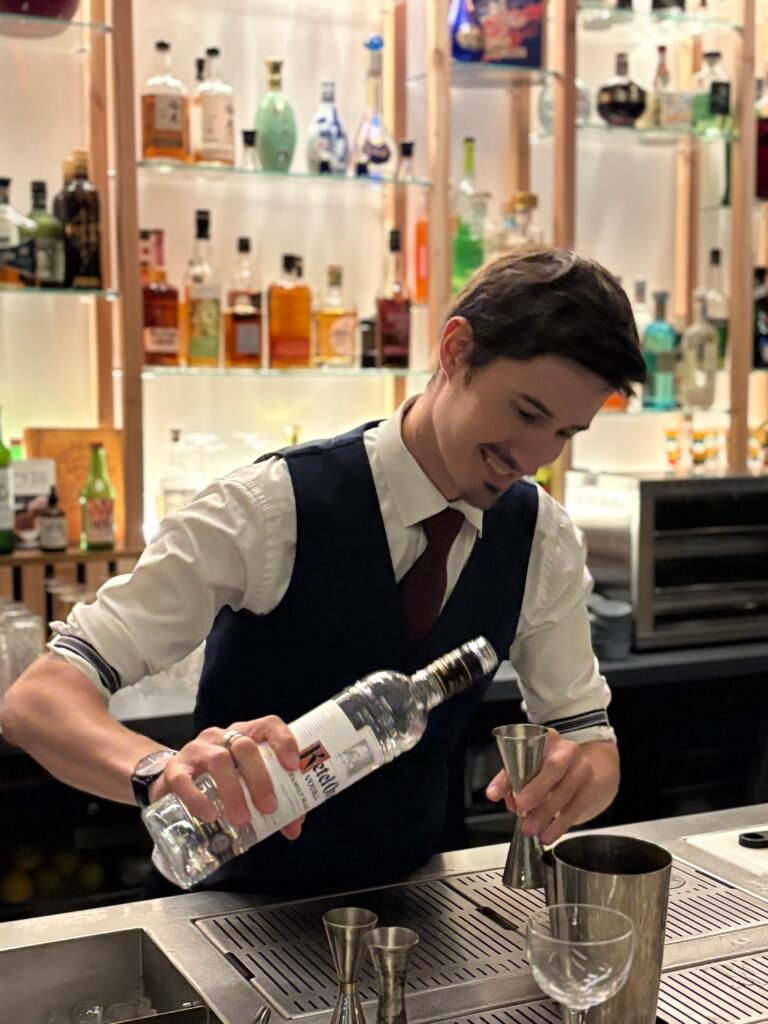 Barman mesurant un spiritueux avec un jigger pour doser une boisson